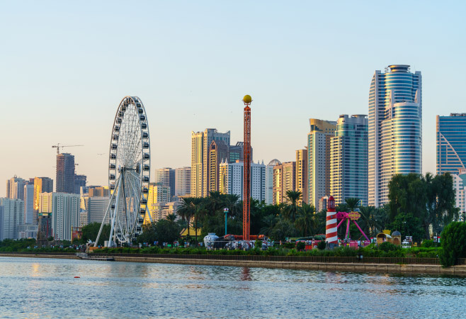 Sharjah cityscape and Eye of the Emirates giant wheel at Al Montazah Park